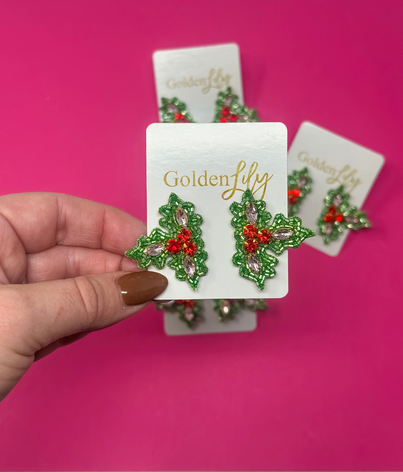 Christmas holly stud earrings with green leaves and red berry details.