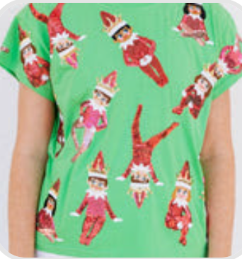 Model wearing Queen of Sparkles Elf Tee featuring sparkling elf designs and festive holiday details.